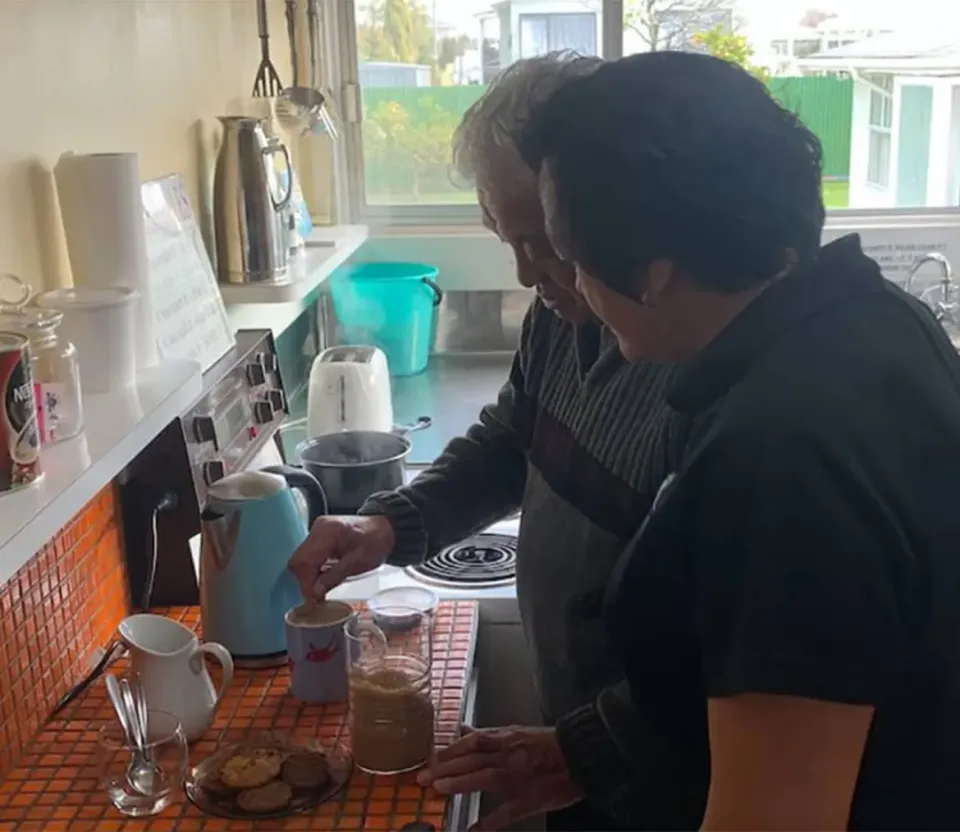 Te Puna Ora o Mataatua worker helping an older person prepare a drink in a kitchen