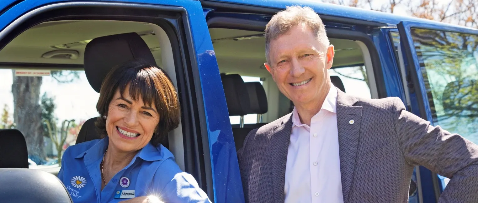 Driving Miss Daisy driver and colleague smiling beside an open vehicle door